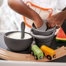 Ladda upp bild till gallerivisning, Ett barn som stoppar handen i en grå snacks mugg